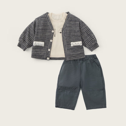 A toddler clothing set featuring a dark gray and white textured tweed cardigan with a cream inner lining, paired with dark gray pants, displayed on a light beige background with 'jacinda bebe' and 'lovely kids' text.