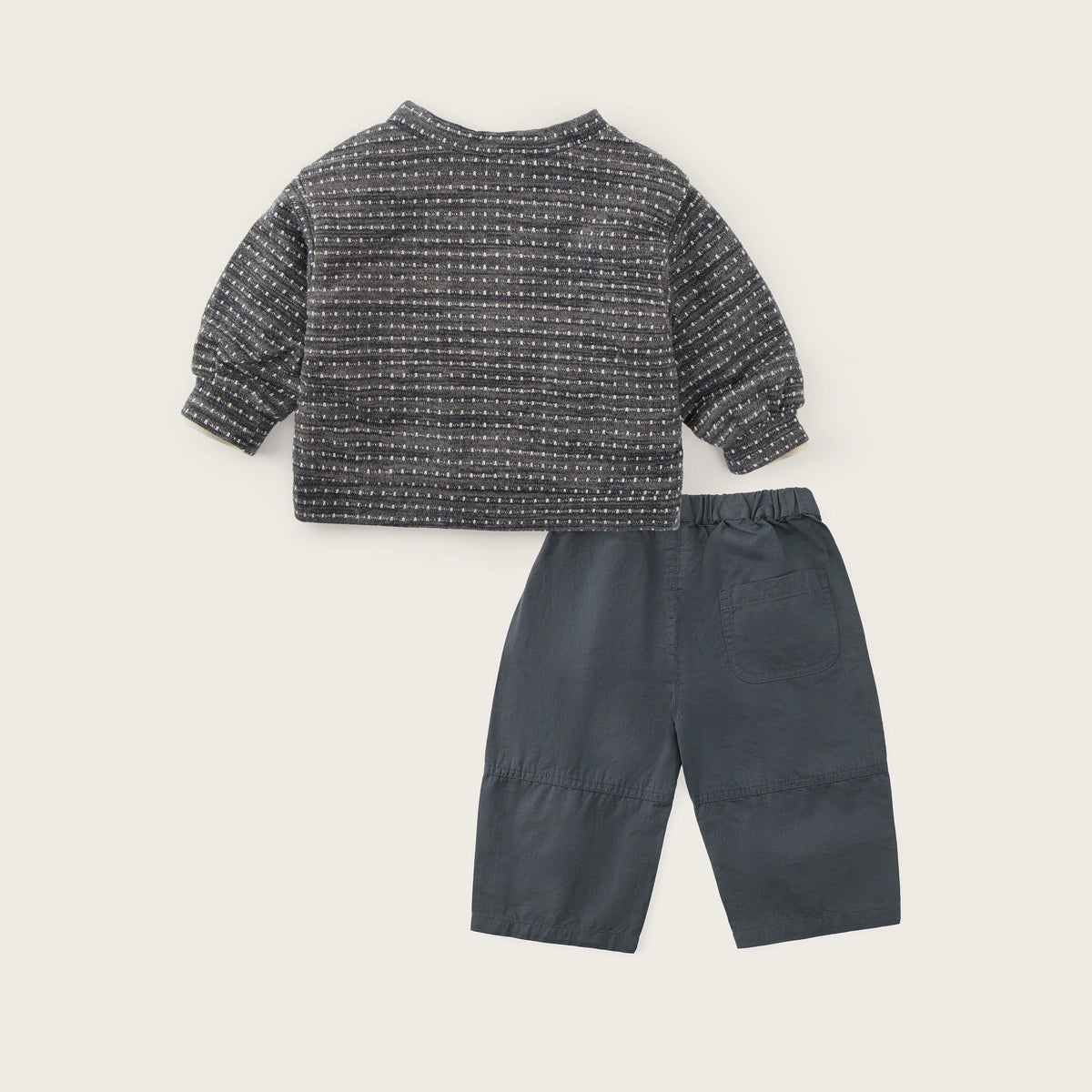 A baby clothing set featuring a dark gray and white textured knit long-sleeve top and dark gray pants, displayed on a light beige background with 'jacinda bebe' and 'lovely kids' text.
