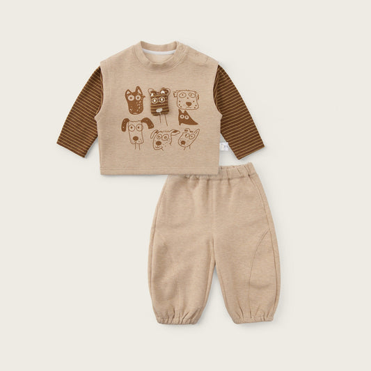 A toddler two-piece outfit set featuring a beige long-sleeve top with brown striped sleeves and a dog-themed graphic print, paired with matching beige pants, displayed on a light beige background with 'jacinda bebe' and 'lovely kids' text.