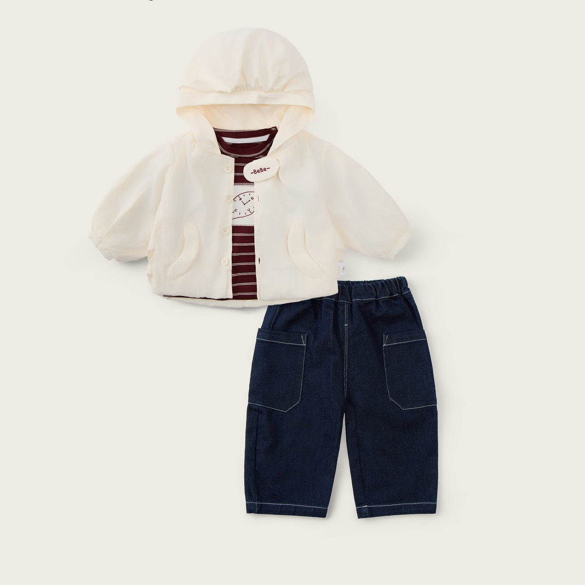 A baby clothing set featuring an off-white hooded cardigan with a striped shirt underneath and dark blue denim shorts, displayed on a light beige background with 'jacinda bebe' and 'lovely kids' text.