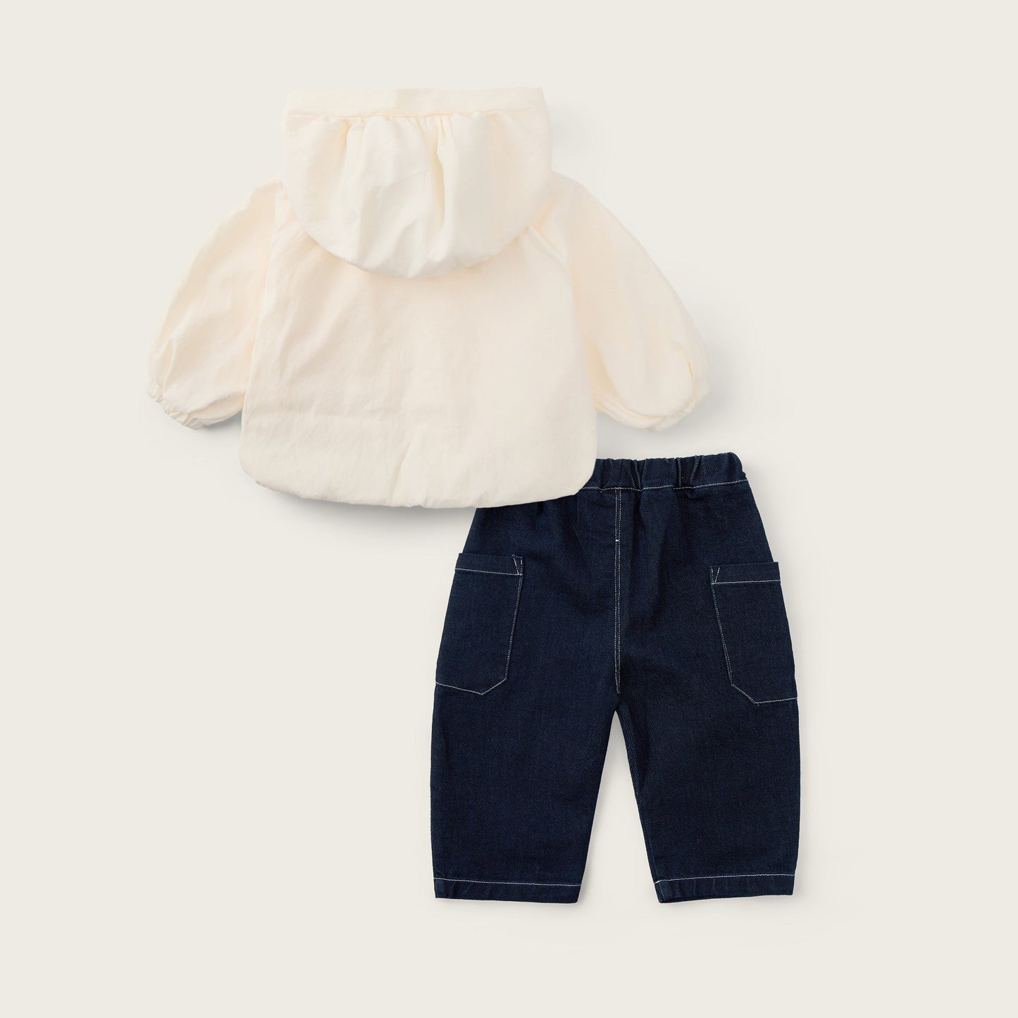A baby outfit set featuring a cream hooded jacket and navy blue shorts, displayed on a light beige background with 'jacinda bebe' at the top and 'lovely kids' at the bottom.
