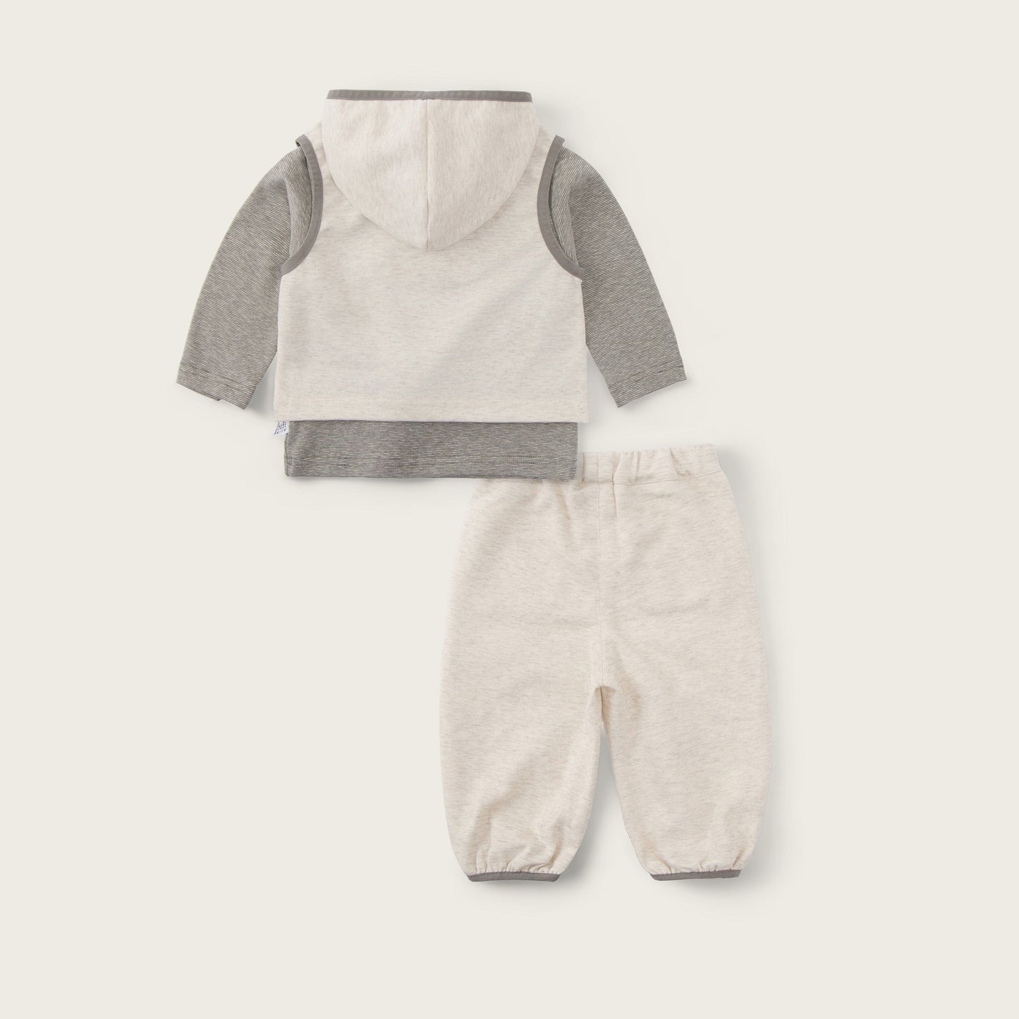 Baby two-piece outfit set featuring a hooded long-sleeve top and matching pants in a cream and heather gray colorway, displayed on a light beige background with 'jacinda bebe' and 'lovely kids' text.