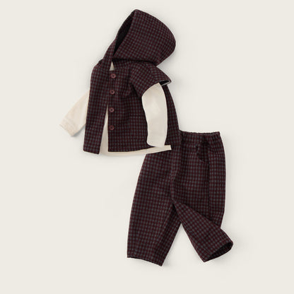 A baby clothing set laid flat on a light cream background, featuring a dark burgundy and black checkered hooded vest over a cream long-sleeve shirt, paired with matching checkered pants. The text 'jacinda bebe' appears at the top and 'lovely kids' at the bottom.