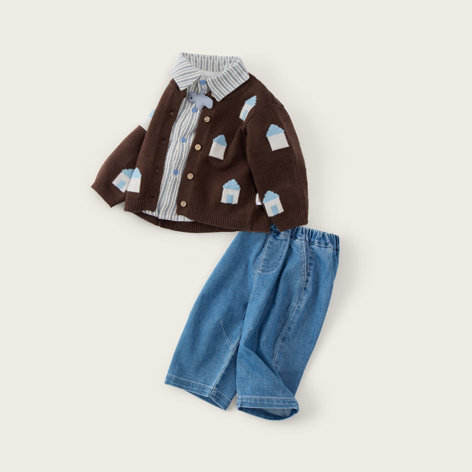 A children's outfit set featuring a brown cardigan with small blue and white house prints over a striped shirt, paired with blue denim shorts, displayed on a light beige background with 'jacinda bebe' and 'lovely kids' text.