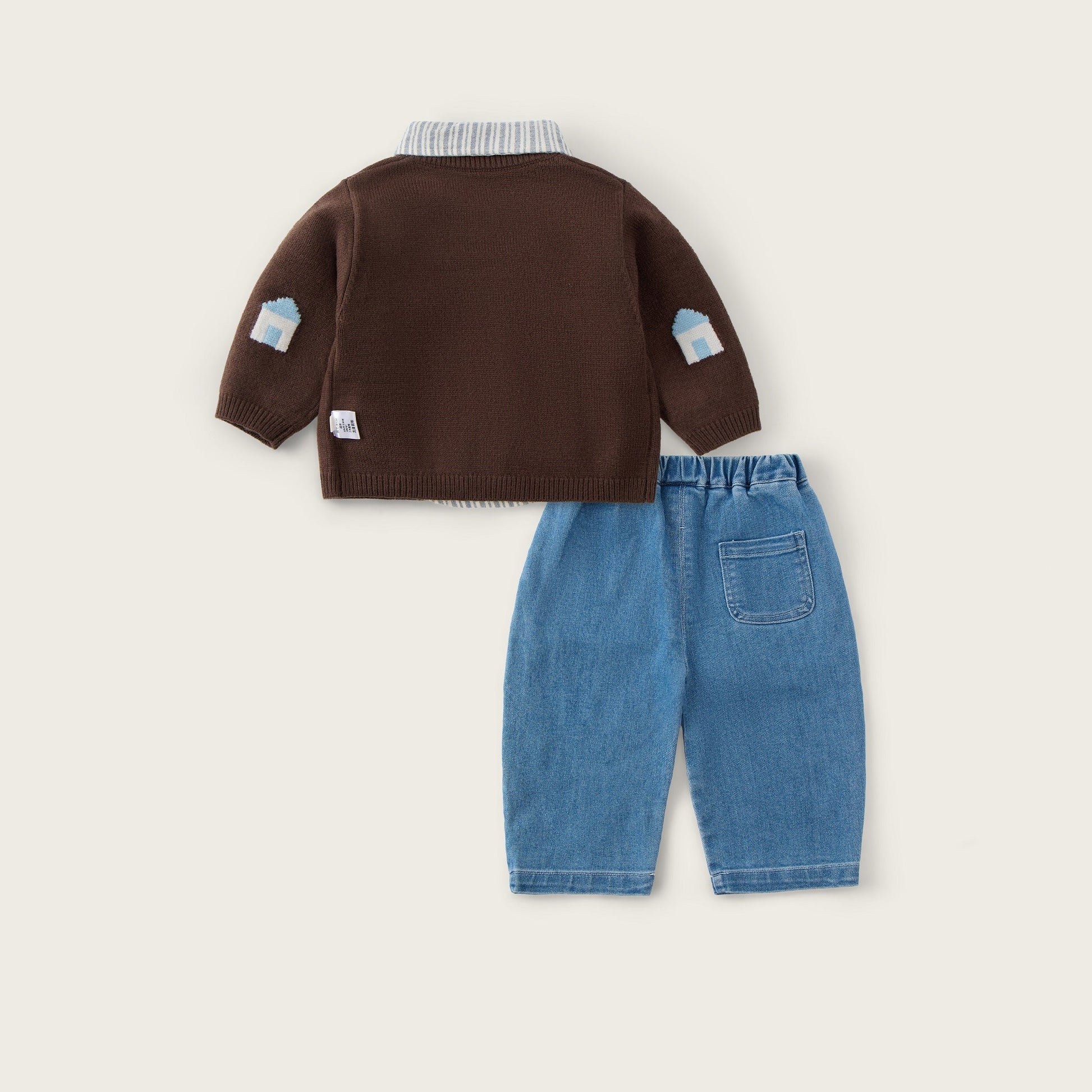 A children's outfit set featuring a dark brown knit cardigan with light blue patch details on the sleeves and a matching pair of light blue denim pants, displayed on a warm off-white background with 'jacinda bebe' at the top and 'lovely kids' at the bottom.