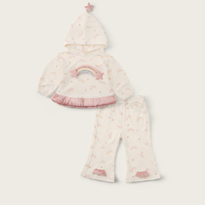 A baby girl's two-piece pajama set from Jacinda Bebe, featuring a hooded top with a pastel rainbow and star print, and matching flared pants, displayed on a light beige background with brand text.