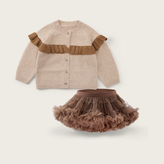 A baby girl's two-piece outfit set featuring a beige knit cardigan with a brown ruffle detail across the chest and a matching brown ruffled tutu skirt, displayed on a light beige background with 'jacinda bebe' and 'lovely kids' text.