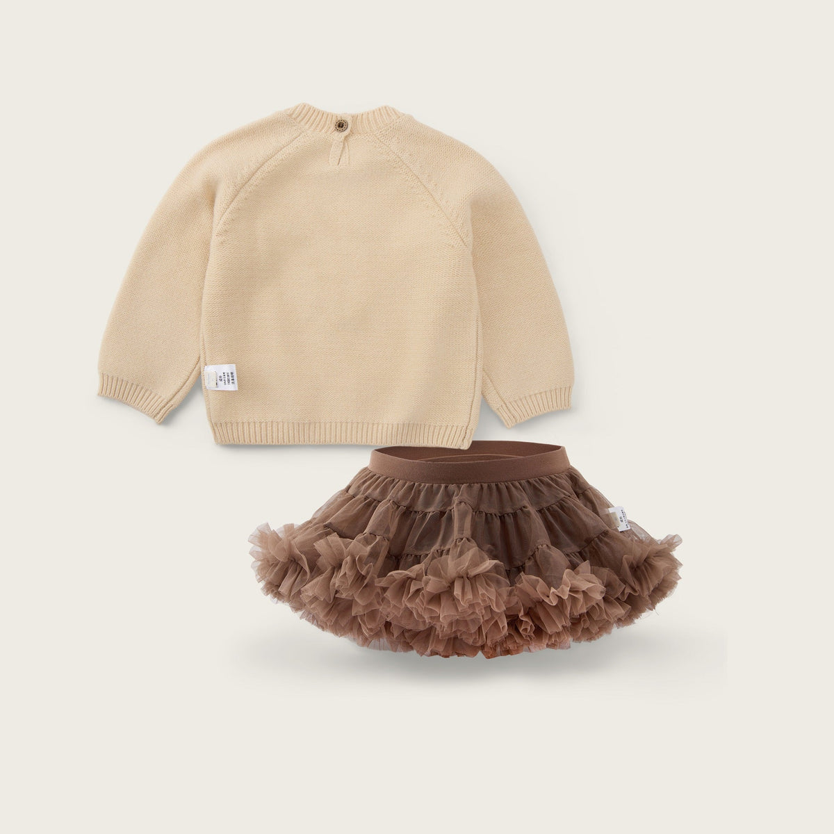 A baby clothing set featuring a beige knit long-sleeve top and a brown ruffled tutu skirt, displayed on a light beige background with the text 'jacinda bebe' at the top and 'lovely kids' at the bottom.