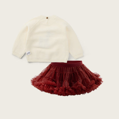 A baby outfit set featuring an off-white long-sleeve knit top and a dark red ruffled tutu skirt, displayed on a light beige background with 'jacinda bebe' at the top and 'lovely kids' at the bottom.