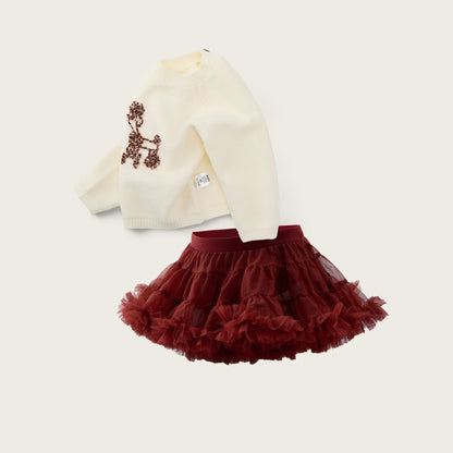 A children's outfit set featuring an off-white long-sleeve top with a brown embroidered dog design and a dark red ruffled tutu skirt, displayed on a light beige background with 'jacinda bebe' and 'lovely kids' text.