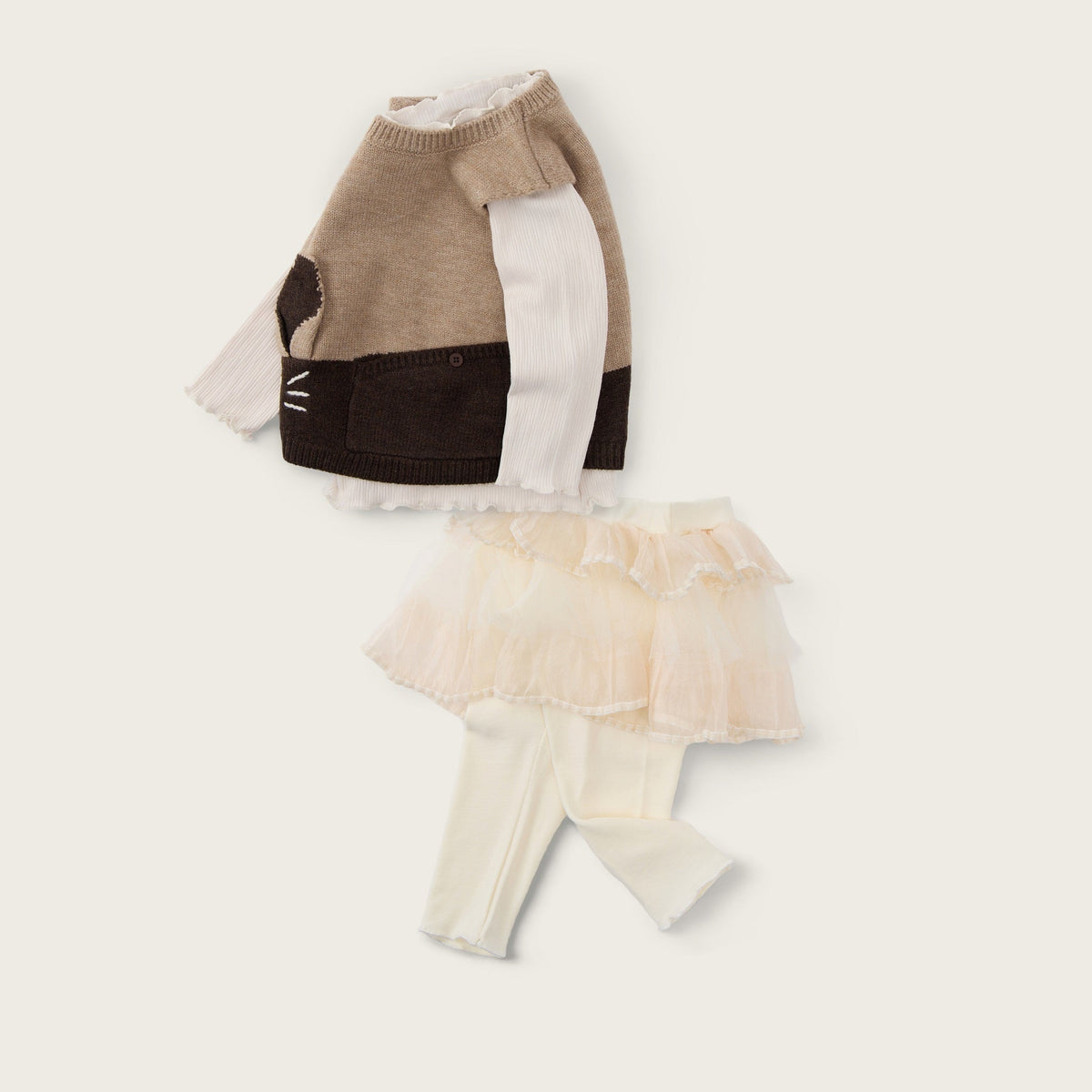 A doll-sized knit sweater and matching tulle skirt set displayed on a cream background with the text 'jacinda bebe' at the top and 'lovely kids' at the bottom.