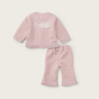A two-piece baby outfit set in light pink ribbed fabric, featuring a long-sleeve top with a white embroidered cloud design on the back and matching ribbed pants, displayed on a light beige background with 'jacinda bebe' and 'lovely kids' text.