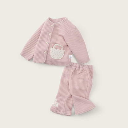 A two-piece baby outfit set in light pink ribbed corduroy, featuring a long-sleeve cardigan with a white embroidered basket detail on the chest and matching ribbed pants, displayed on a warm off-white background with 'jacinda bebe' and 'lovely kids' text.