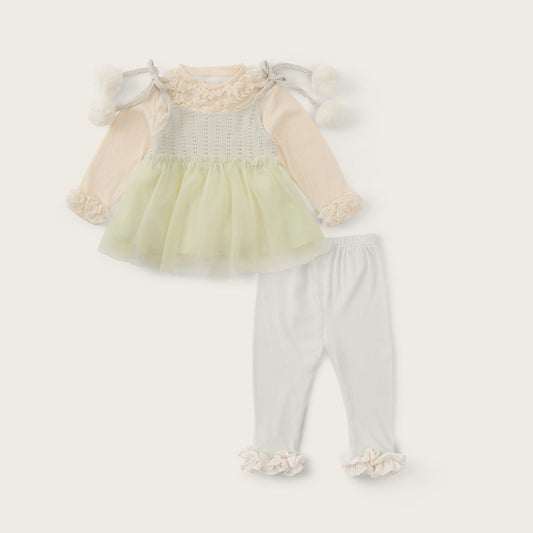 A baby girl's two-piece outfit set featuring a pale yellow tulle tutu dress with cream long sleeves and white pom-pom shoulder details, paired with white leggings with cream ruffle cuffs. The image is presented on a warm cream background with 'jacinda bebe' at the top and 'lovely kids' at the bottom.