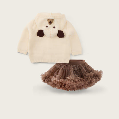 A baby clothing set featuring a cream-colored knit sweater with a brown bear face applique and a matching brown ruffled tutu skirt, displayed on a light beige background with 'jacinda bebe' and 'lovely kids' text.