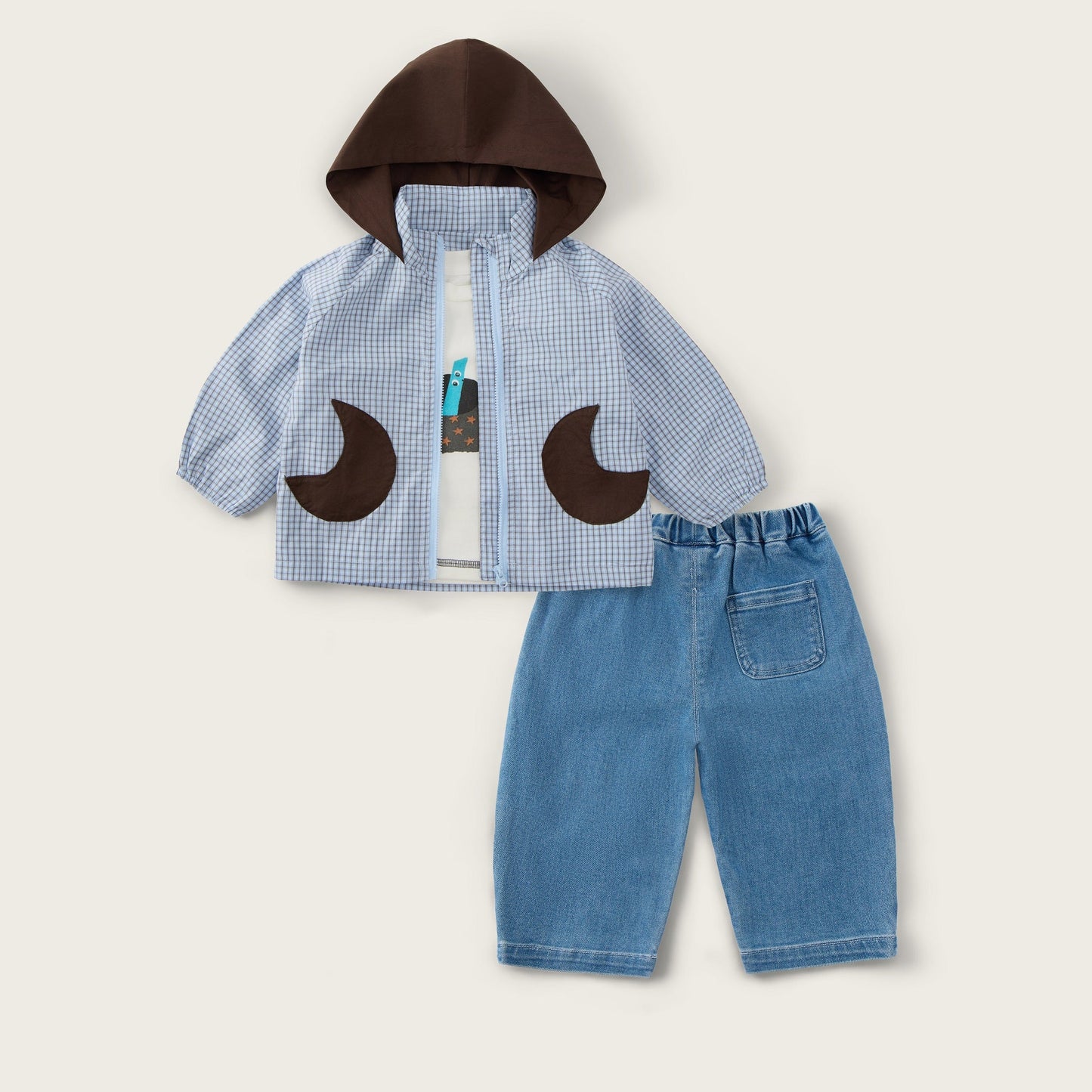 A children's outfit set featuring a light blue and white gingham zip-up jacket with a dark brown hood and matching brown crescent moon appliques, paired with light blue denim shorts. The brand names 'jacinda bebe' and 'lovely kids' are printed on the cream-colored background.